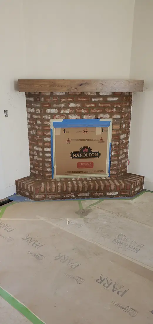 Brick veneer fireplace with wood mantel installation in progress Oregon