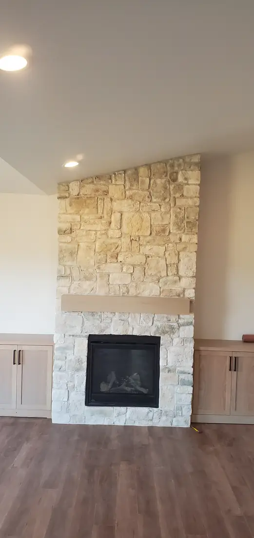 Cream stacked stone veneer fireplace with firebox and hardwood floor Oregon