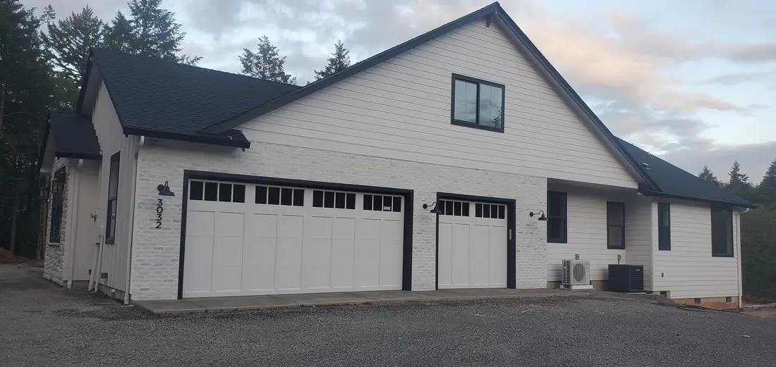 White farmhouse exterior with gray gable and garage Oregon