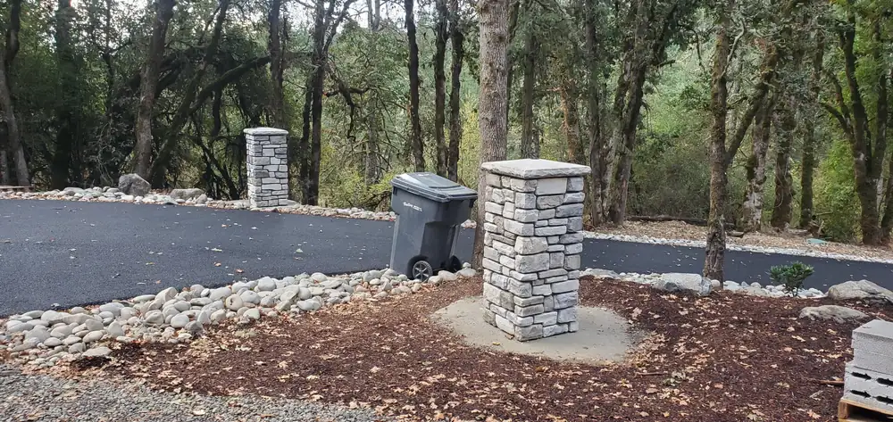 Outdoor stone veneer pillar with enclosure on forest driveway Oregon