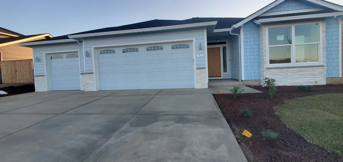 New construction ranch home exterior with three-car garage Oregon
