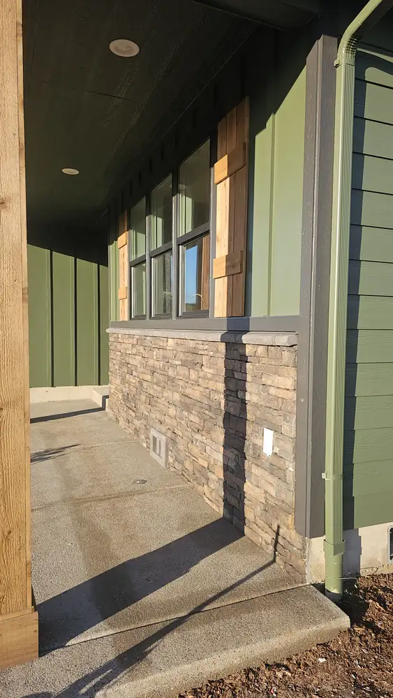 Home exterior with stone veneer wainscot and covered patio Oregon