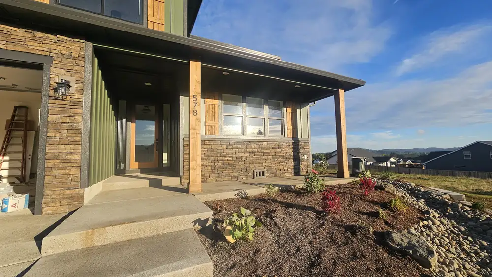 Modern home exterior with stone veneer and landscaping Oregon