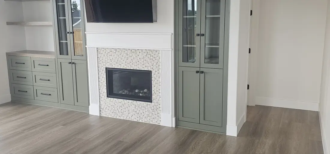 White fireplace with mosaic tile accent and green built-in cabinets Oregon