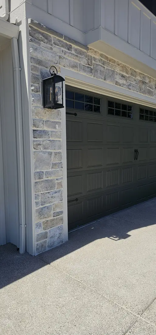 Stone veneer wainscot on home exterior with concrete walkway Oregon